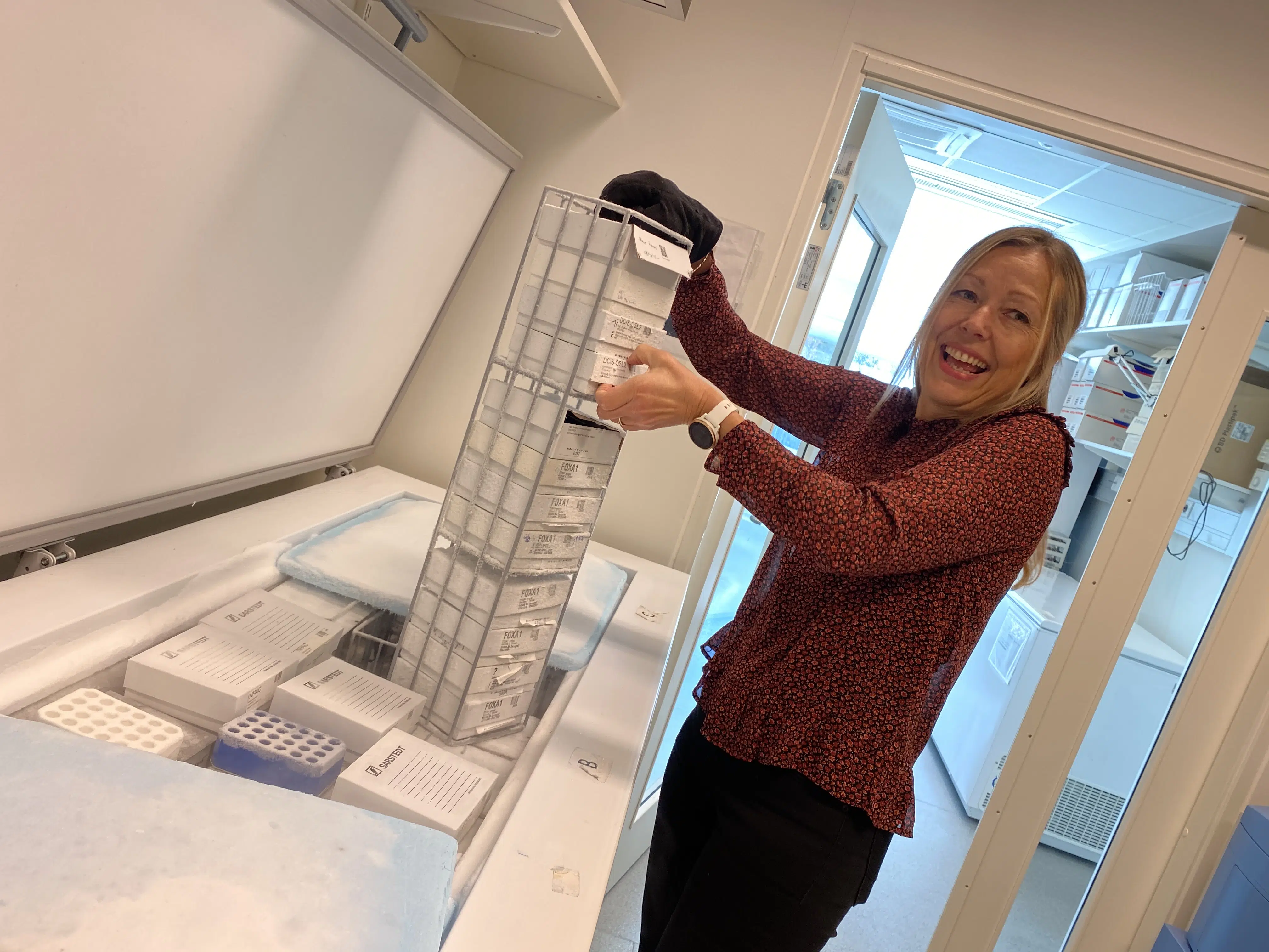 en kvinne som står foran en modell av en bygning.